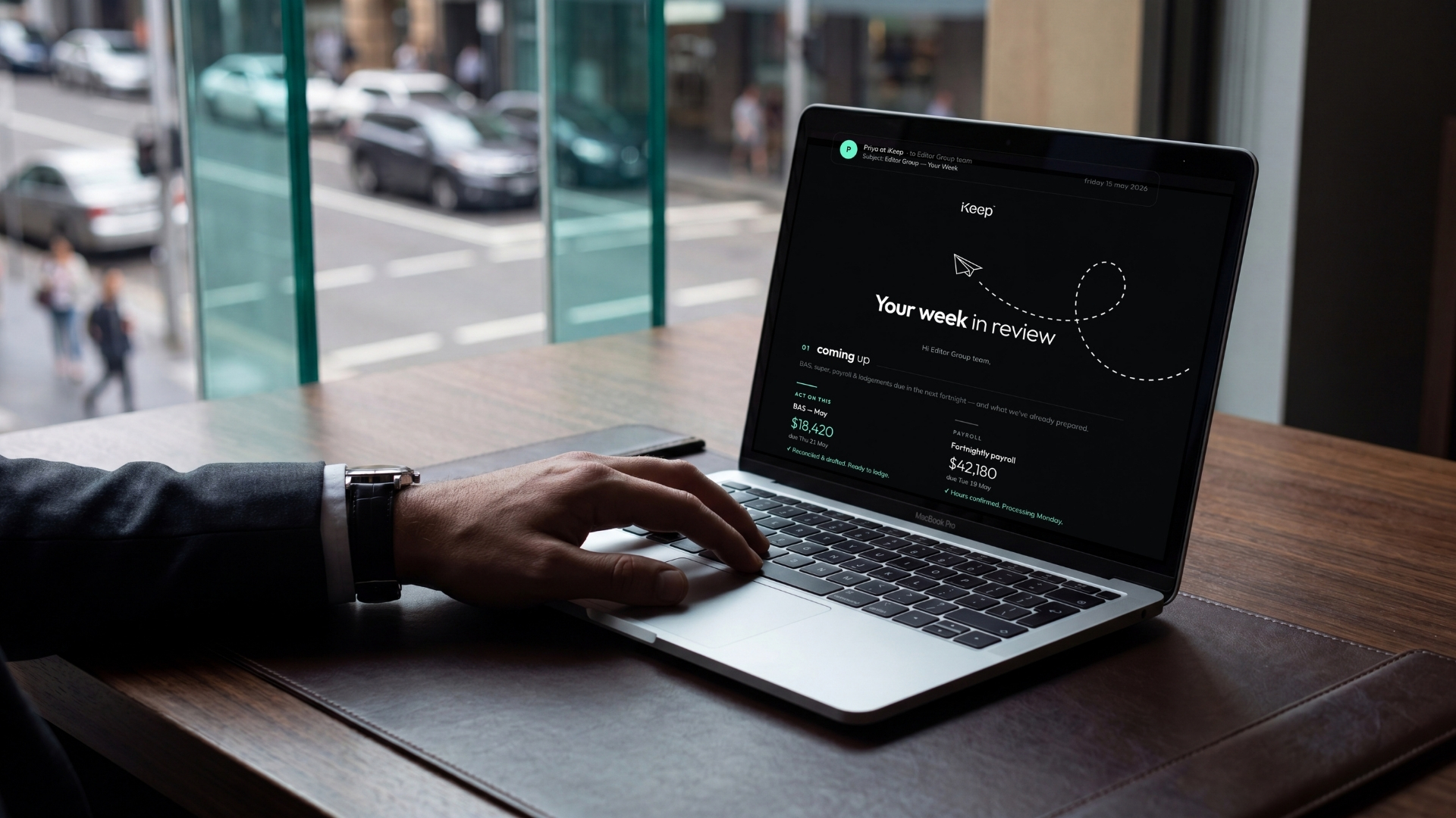 A business owner reading their iKeep Friday Email — a weekly review showing upcoming BAS and payroll figures — on a laptop